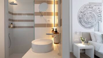 A modern bathroom with a round sink, a handheld showerhead, and a wall-mounted mirror.