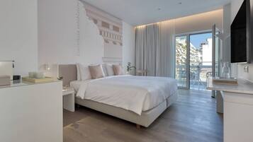 Un dormitorio moderno con una cama grande, una mesita de noche, un escritorio y un balcón con vistas a la ciudad.