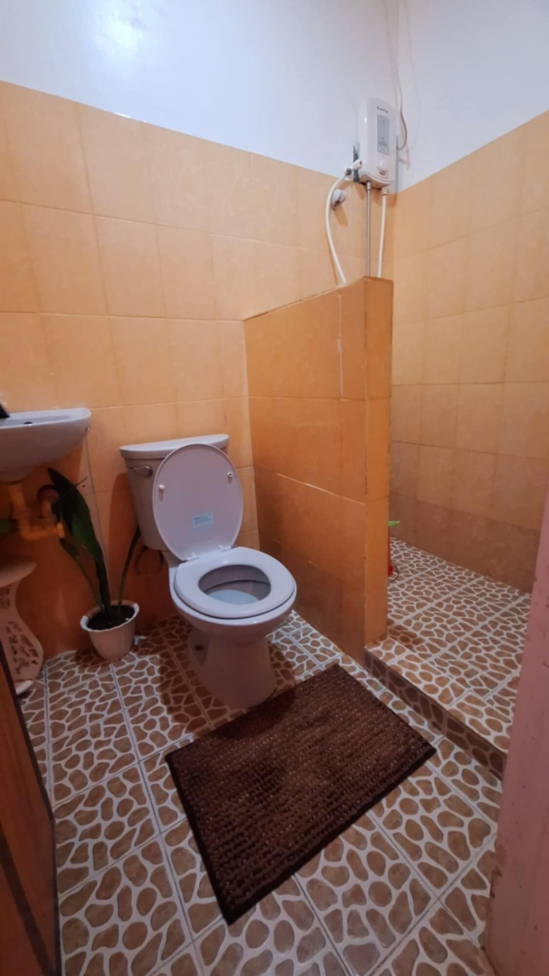 A bathroom with a toilet, sink, and shower.