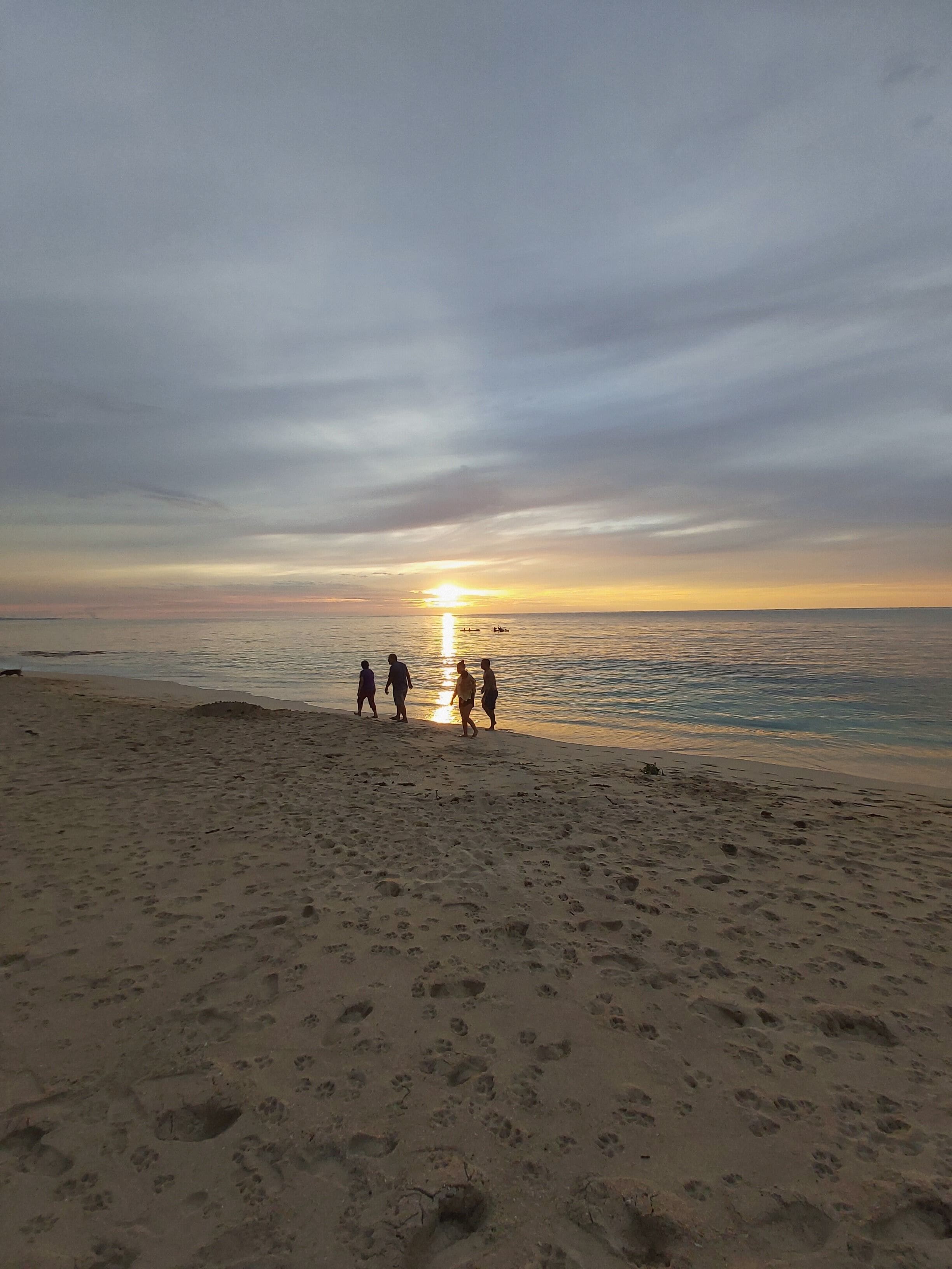 Une plage où l’on voit des empreintes de pas qui mènent à l’eau.