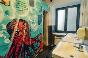 A bathroom with a mural of an octopus, a window, and a sink. - Whole Wide World Hostel & Bar (Zagreb)