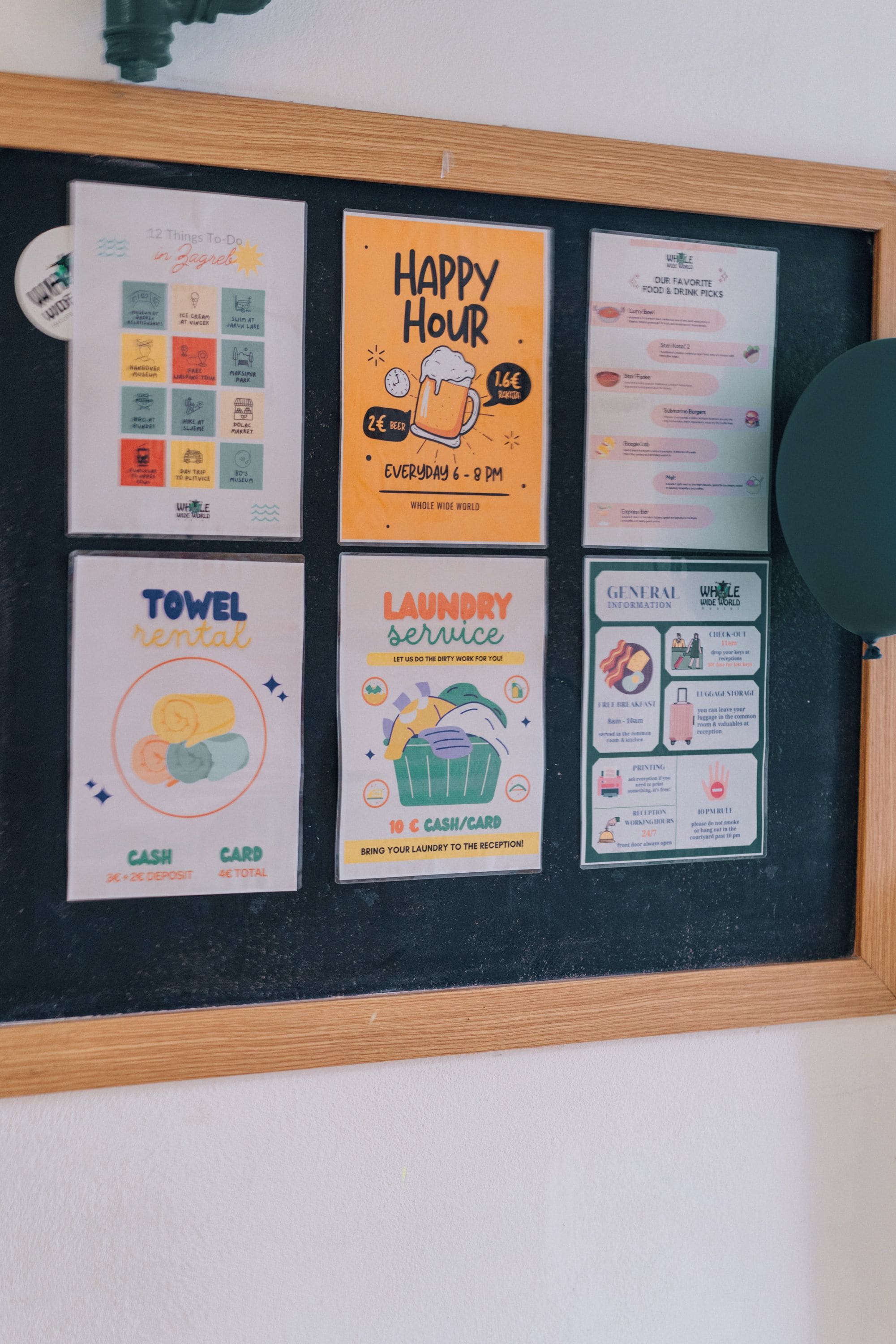 A bulletin board with various informational cards including a Happy Hour sign, towel rental, laundry service, and general information.