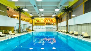 Una piscina interior d'aigües cristal·línes, amb diverses pistes de natació i gandules al voltant.