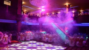 A ballroom with a checkered dance floor, tables set for a reception, and a chandelier. - Rojina Hotel (Amman)