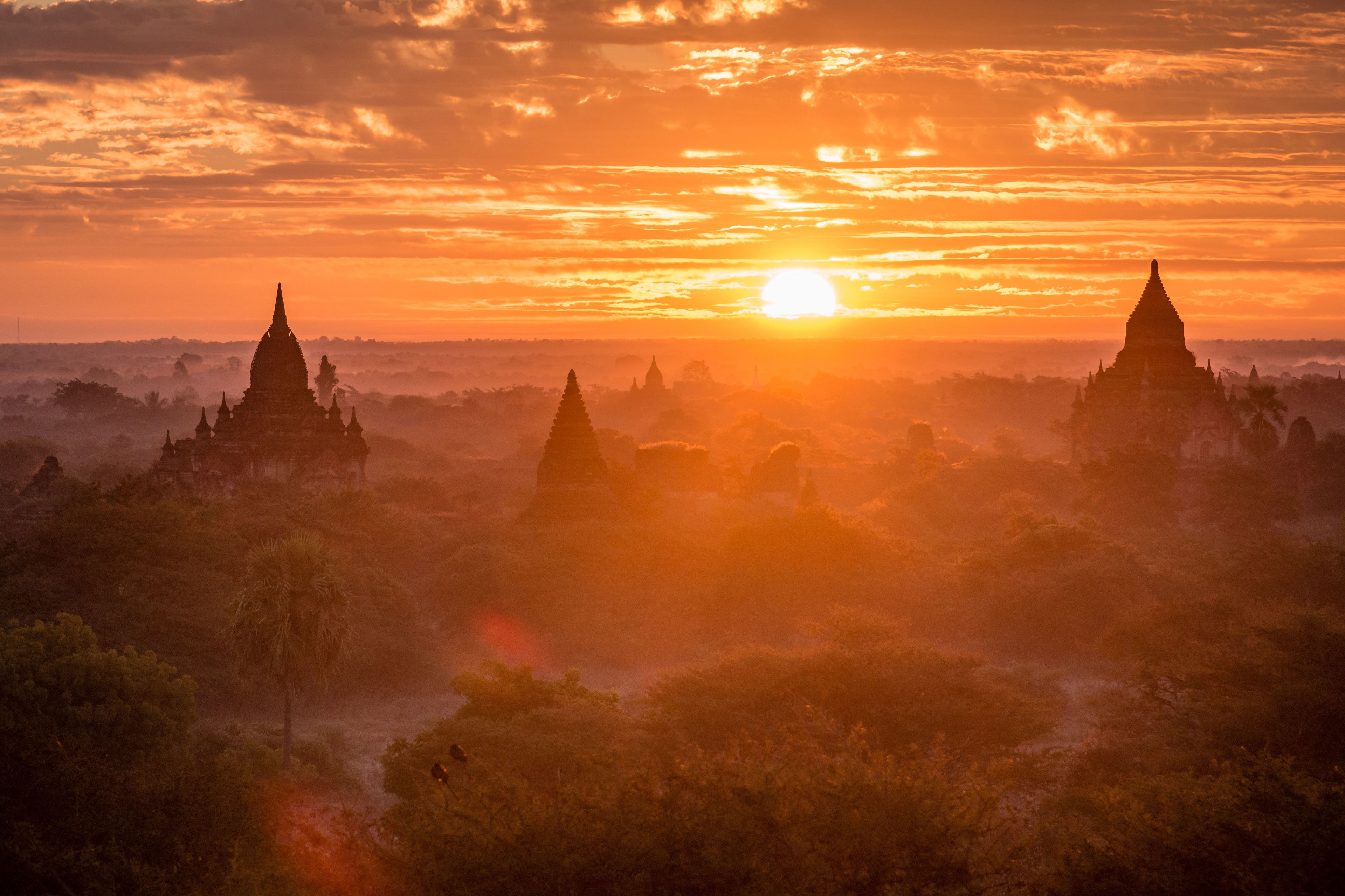 A sunset view of a temple complex with multiple structures.