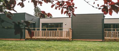 Un edificio moderno con una terraza de madera y un espacio al aire libre techado.