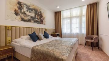 Une chambre d’hôtel avec un grand lit, une table de chevet, une chaise et un tableau au mur.