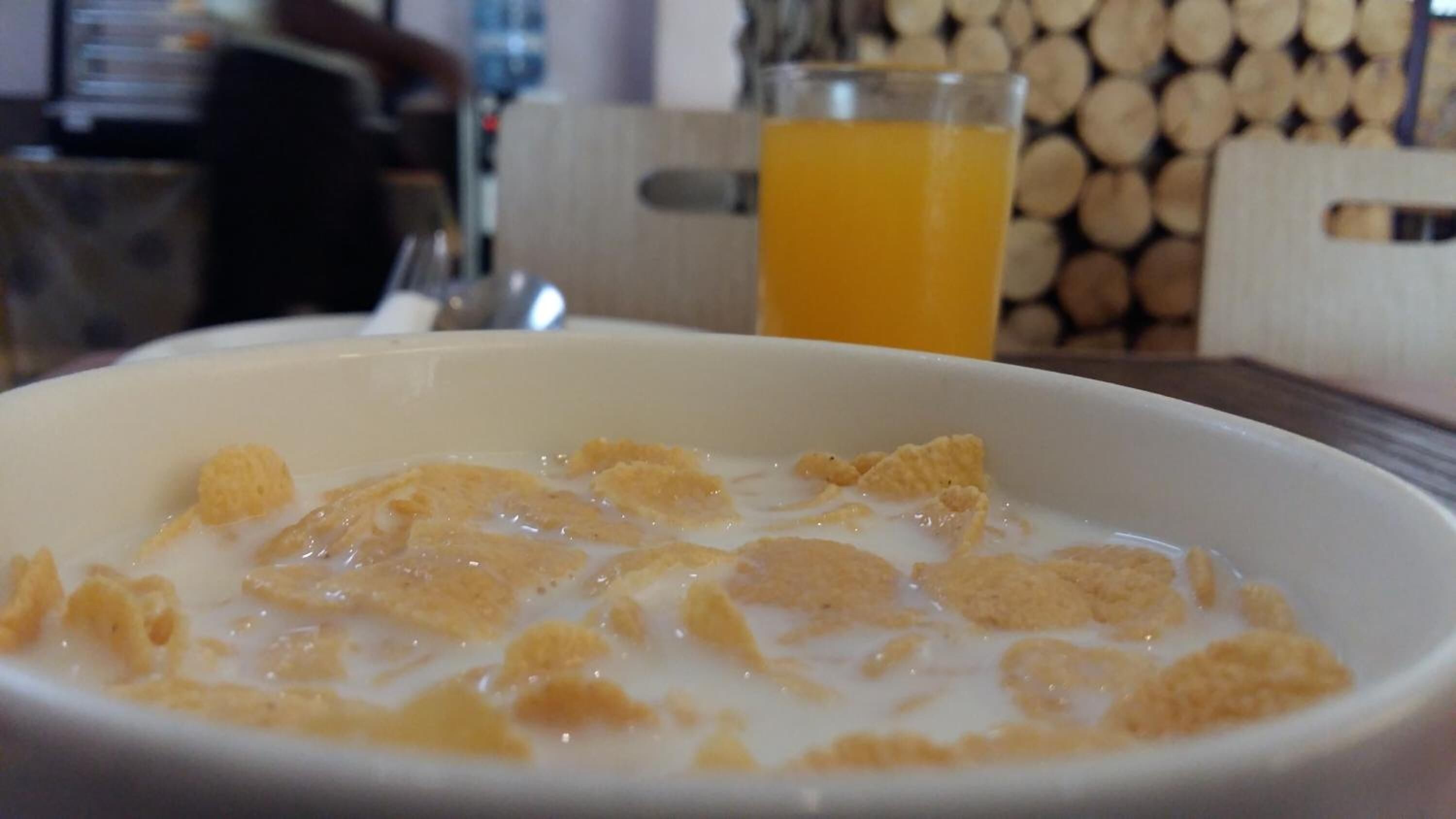 A bowl of cereal with milk on a table.