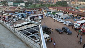 A busy parking lot with multiple buses, cars, and people. - Namayiba Park Hotel (Kampala)