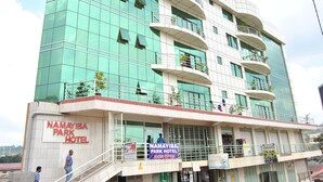 A multi-story hotel with a sign indicating it is the Namayiba Park Hotel. - Namayiba Park Hotel (Kampala)