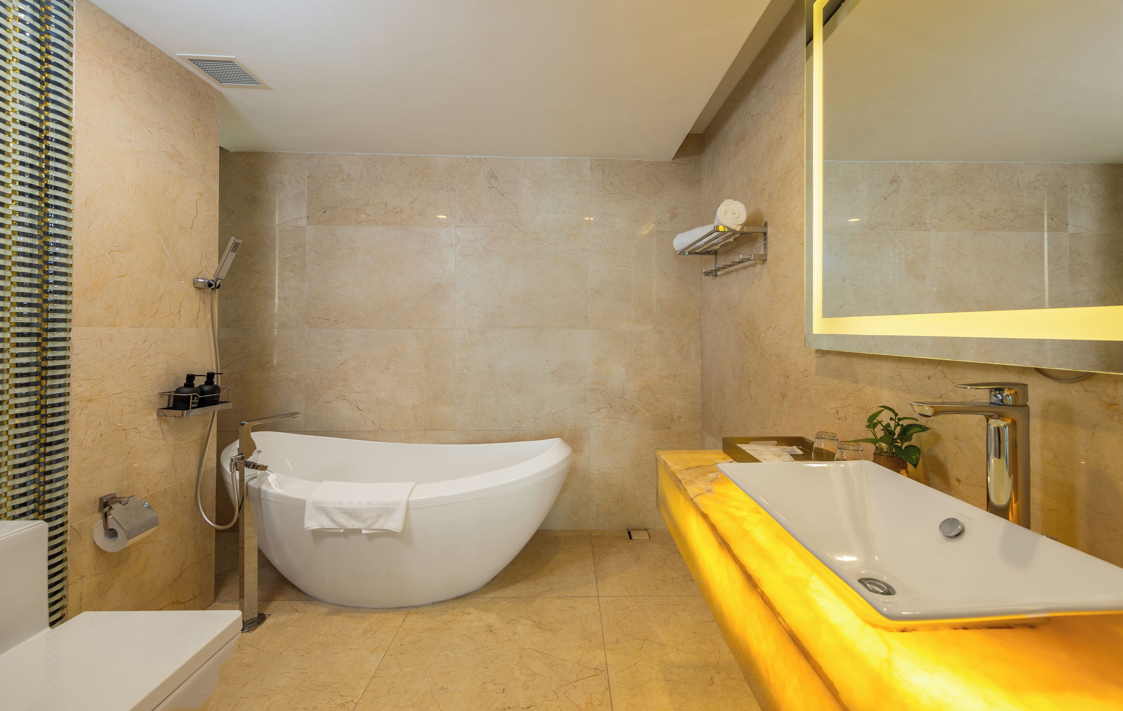 A modern bathroom with a freestanding bathtub, a large mirror, and a vanity with a sink.