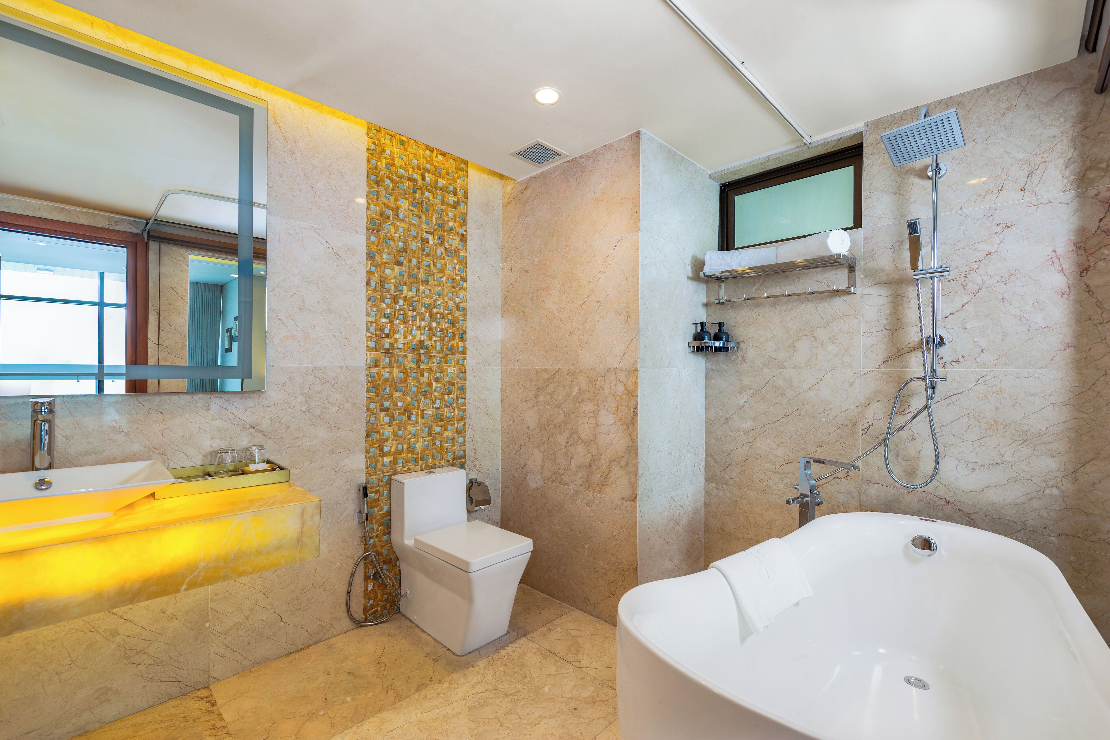 A modern bathroom with a large bathtub, a toilet, and a sink.