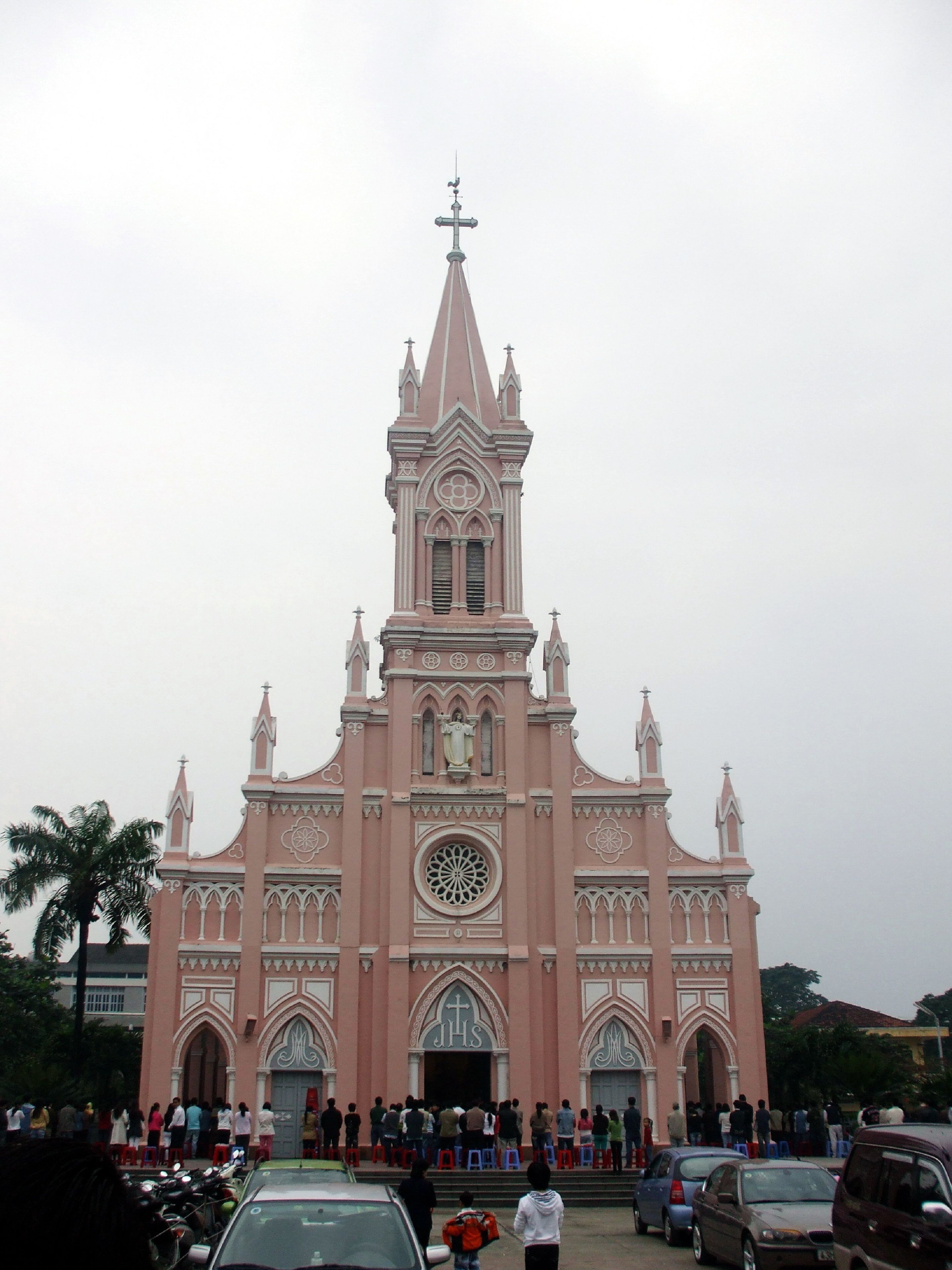 A large church with a tall spire and a circular window in the center.