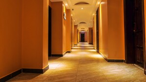 A long, well-lit hallway with a tiled floor and a series of doors on one side. - Russel Hotel (Kampala)