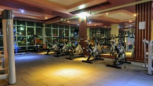 A gym with stationary bikes arranged in rows, large windows, and a modern interior design. - Russel Hotel (Kampala)