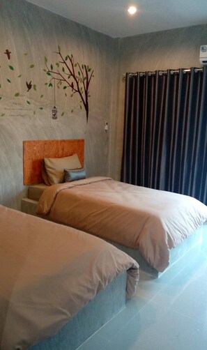 Une chambre d’hôtel avec deux lits, une tête de lit, une fresque murale et un rideau.