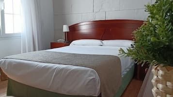 Escritorio, cortinas blackout y tabla de planchar con plancha