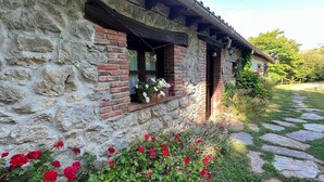 Un rústico edificio de piedra con un vano de ladrillo y un camino de piedra que lo lleva a él.