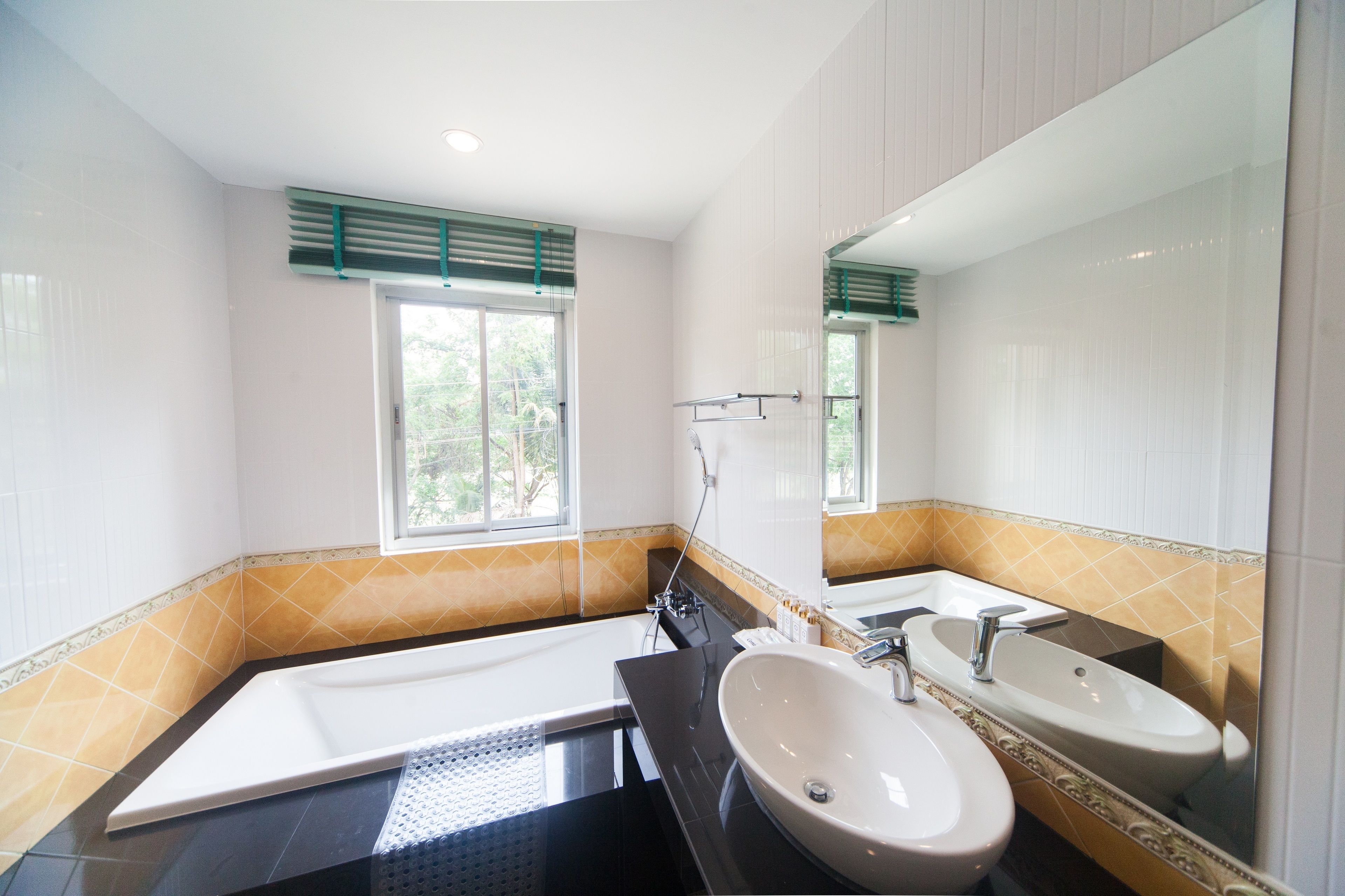 Un baño moderno con una bañera, dos lavamanos y un espejo grande.