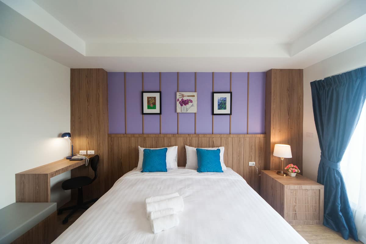 Una camera d'albergo con un letto, una scrivania e una sedia.