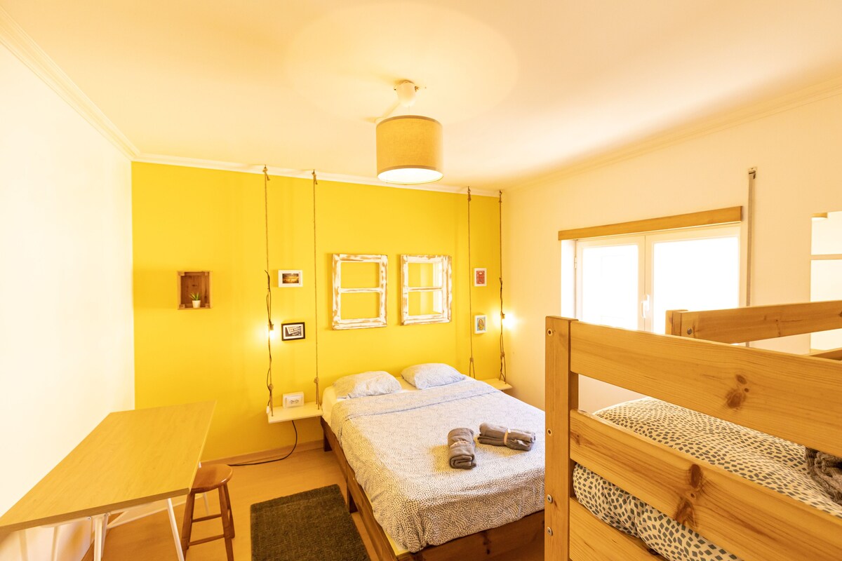 A room with a bed, a desk, and a window.