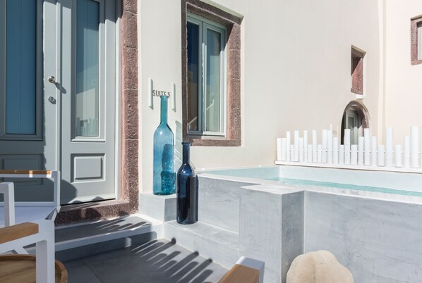 Une chambre d’hôtel moderne avec un lavabo en marbre, un vase bleu et une pancarte indiquant « Suite 5 ».