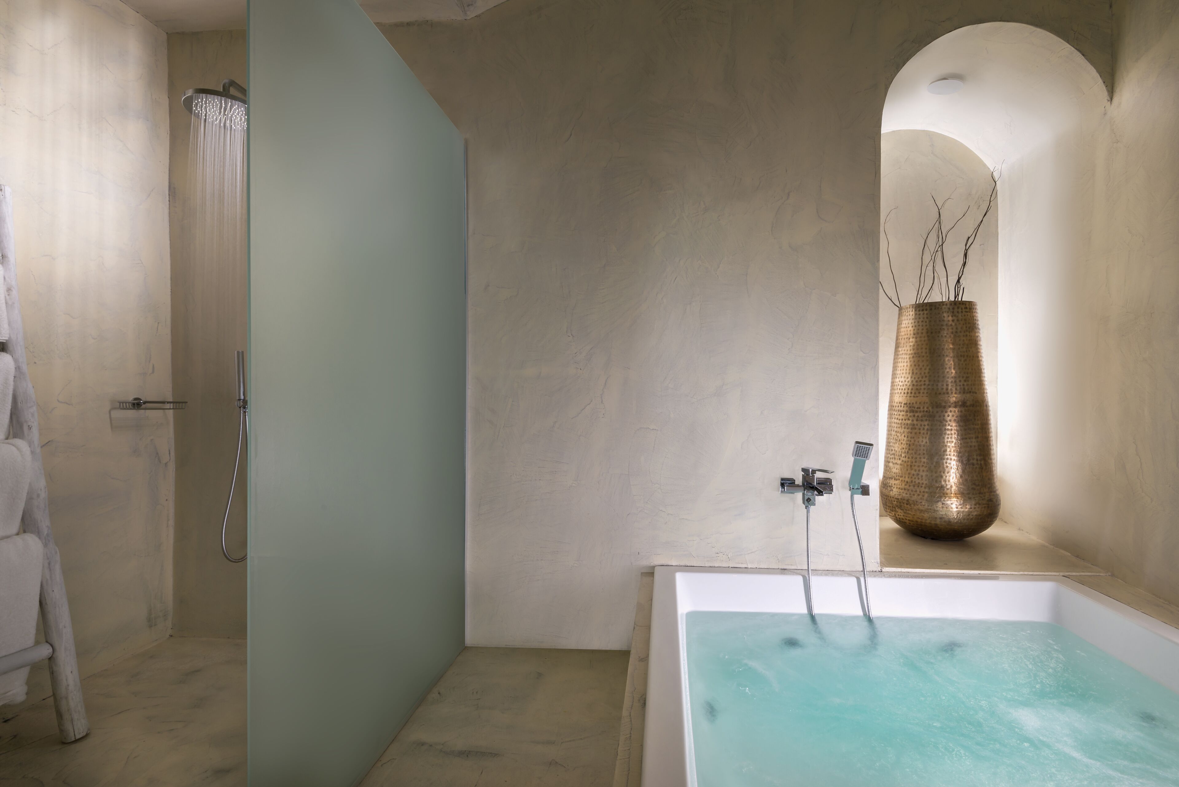 A modern bathroom with a bathtub, shower, and a decorative vase.