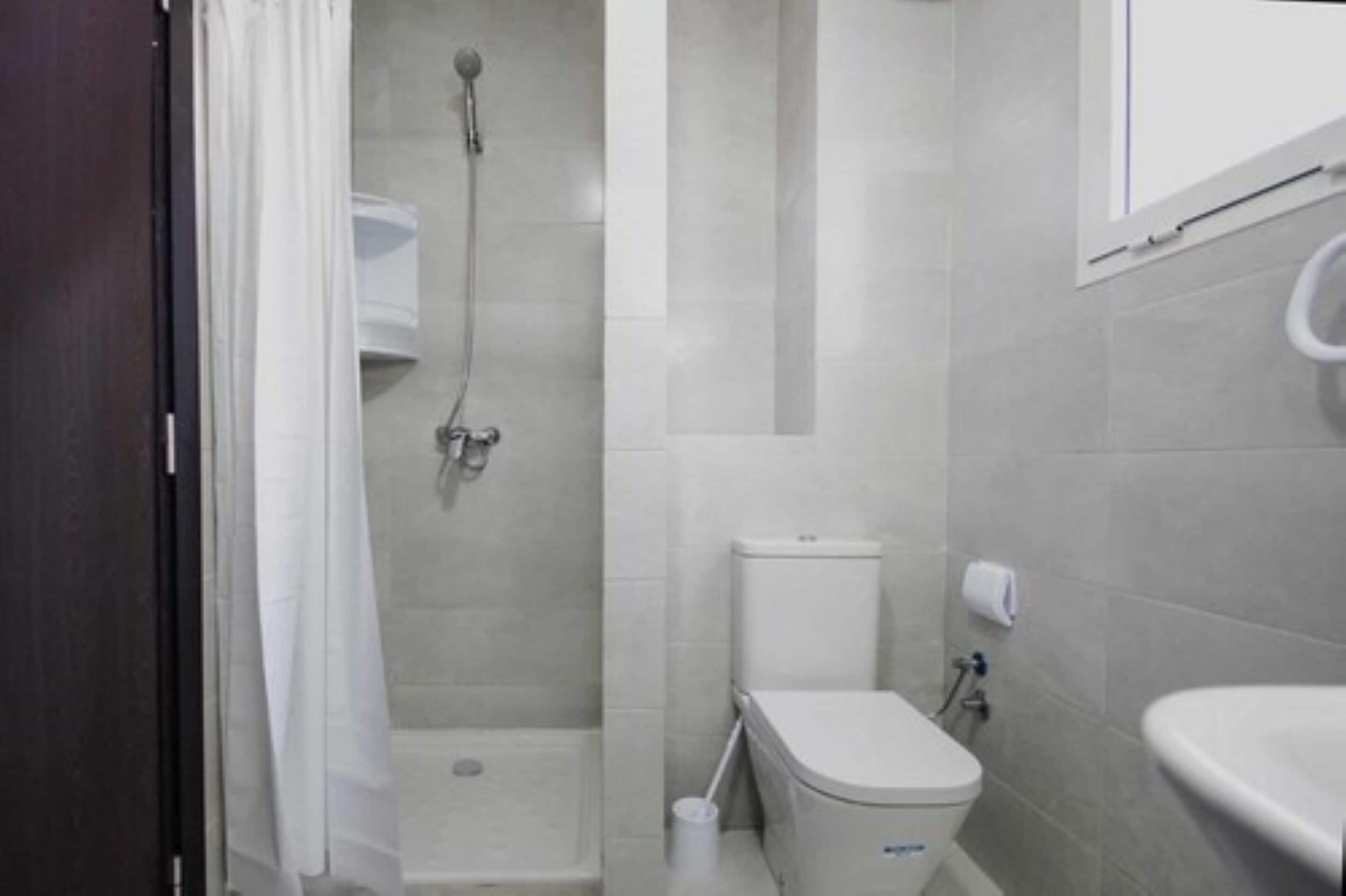 A bathroom with a shower, toilet, and sink.