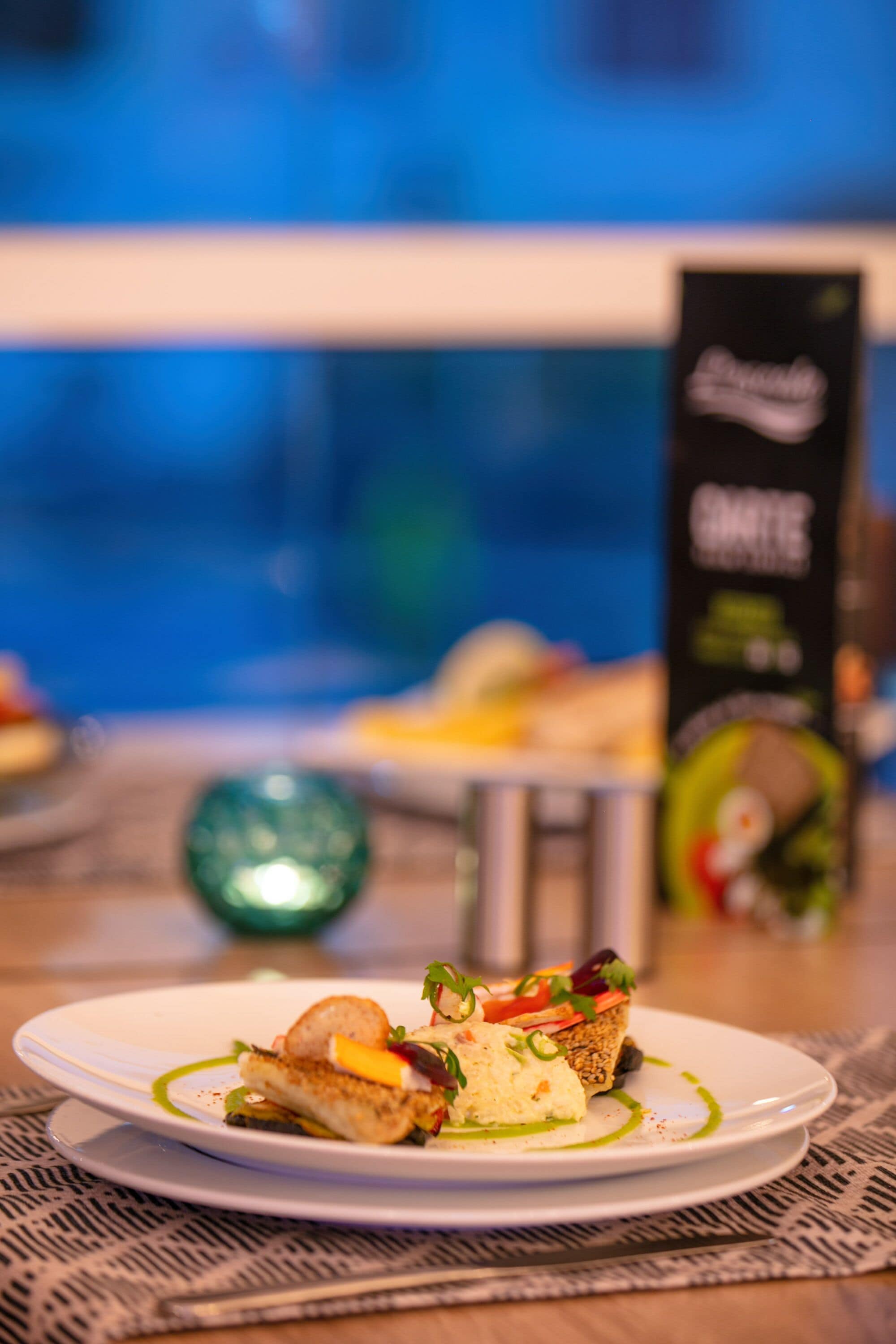 Ein Teller Essen mit grüner Soße, einem Stück Brot und einem kleinen Salat auf einem weißen Teller.