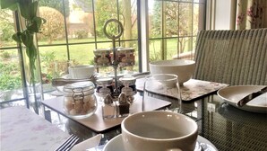 A table set for a meal with a view of the garden through a window. - Coombe House (Cheltenham)