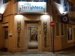 Exterior del Hotel Villa TerraMera con un cartel sobre la entrada, un cartel de 'no entrar' y un letrero de florería.