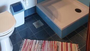 Une salle de bain comprenant un lavabo, des toilettes et un espace douche.