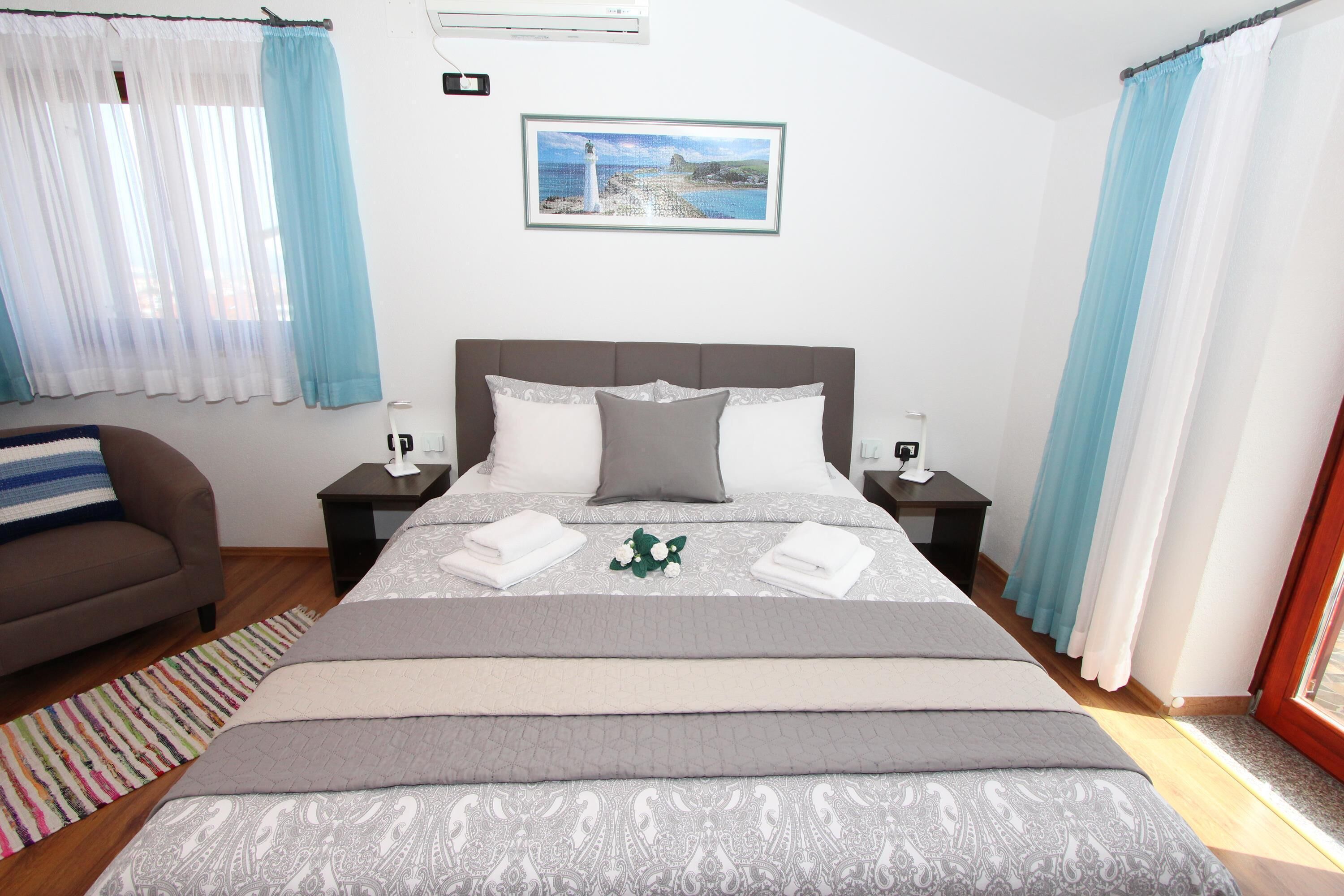 Quarto bem arrumado com uma cama grande, um sofá e uma mesinha.