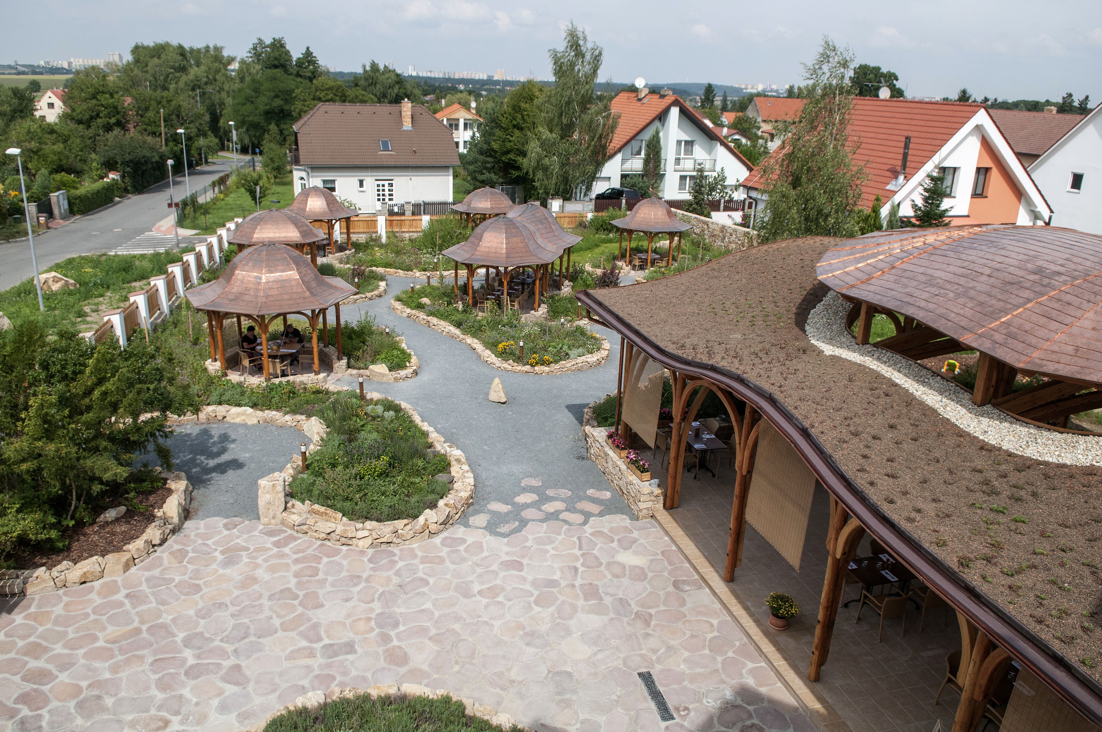 Ein Innenhof mit Steinwegen, hölzernen Lauben und einem Gebäude mit geneigtem Dach.