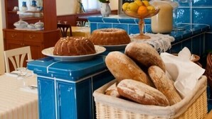 A breakfast buffet with bread, pastries, and fruit. - Babiččina Zahrada Penzion & Restaurace (Pruhonice)