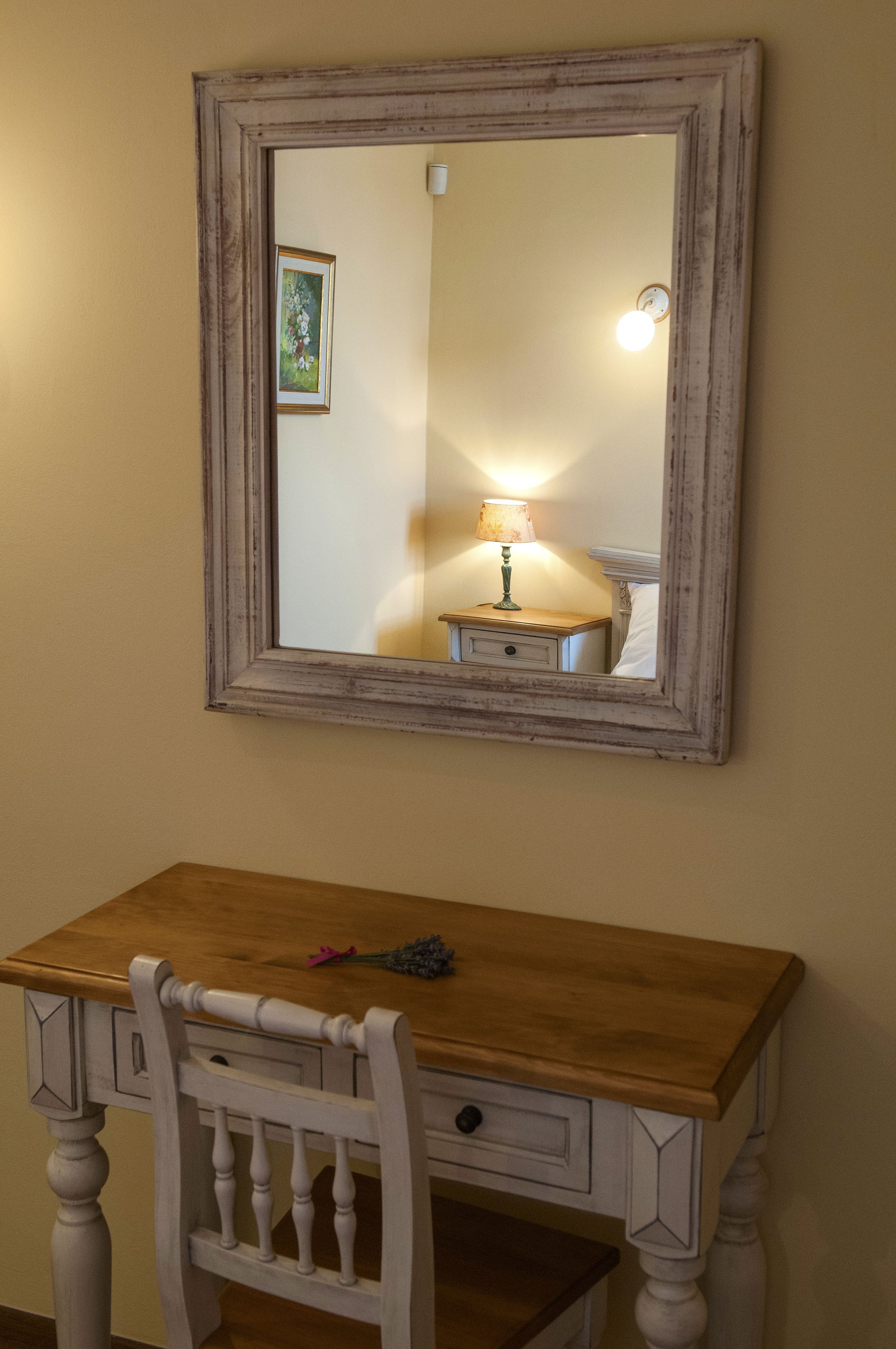 Ein Holztisch mit Stuhl, Spiegel und Lampe.