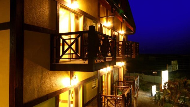 A multi-story building with balconies, a staircase, and a pathway leading to the entrance. - Pulicity B&B (Puli)