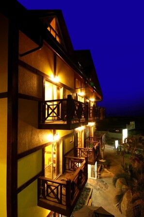 A multi-story building with balconies, a staircase, and a pathway leading to the entrance. - Pulicity B&B (Puli)
