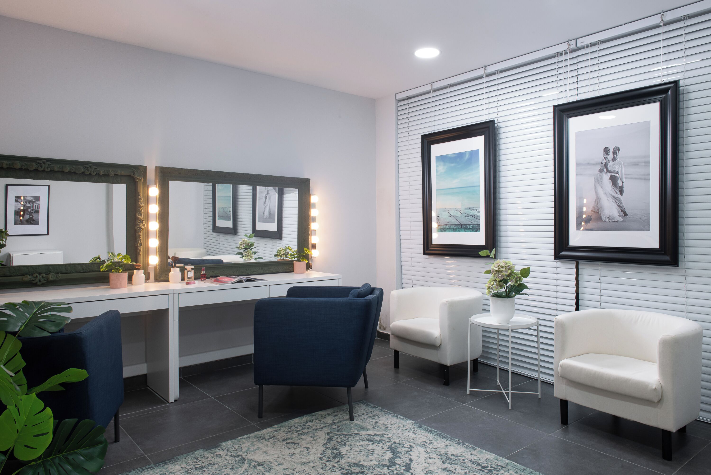 Un baño moderno con tocador, espejos y zona de estar.