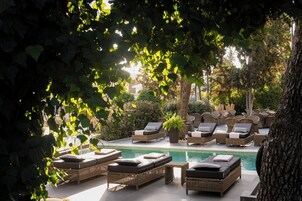 Una piscina al aire libre de temporada, sombrillas
