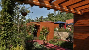 Una casa moderna con fachada de madera, un muro de piedra y un sendero rojo.