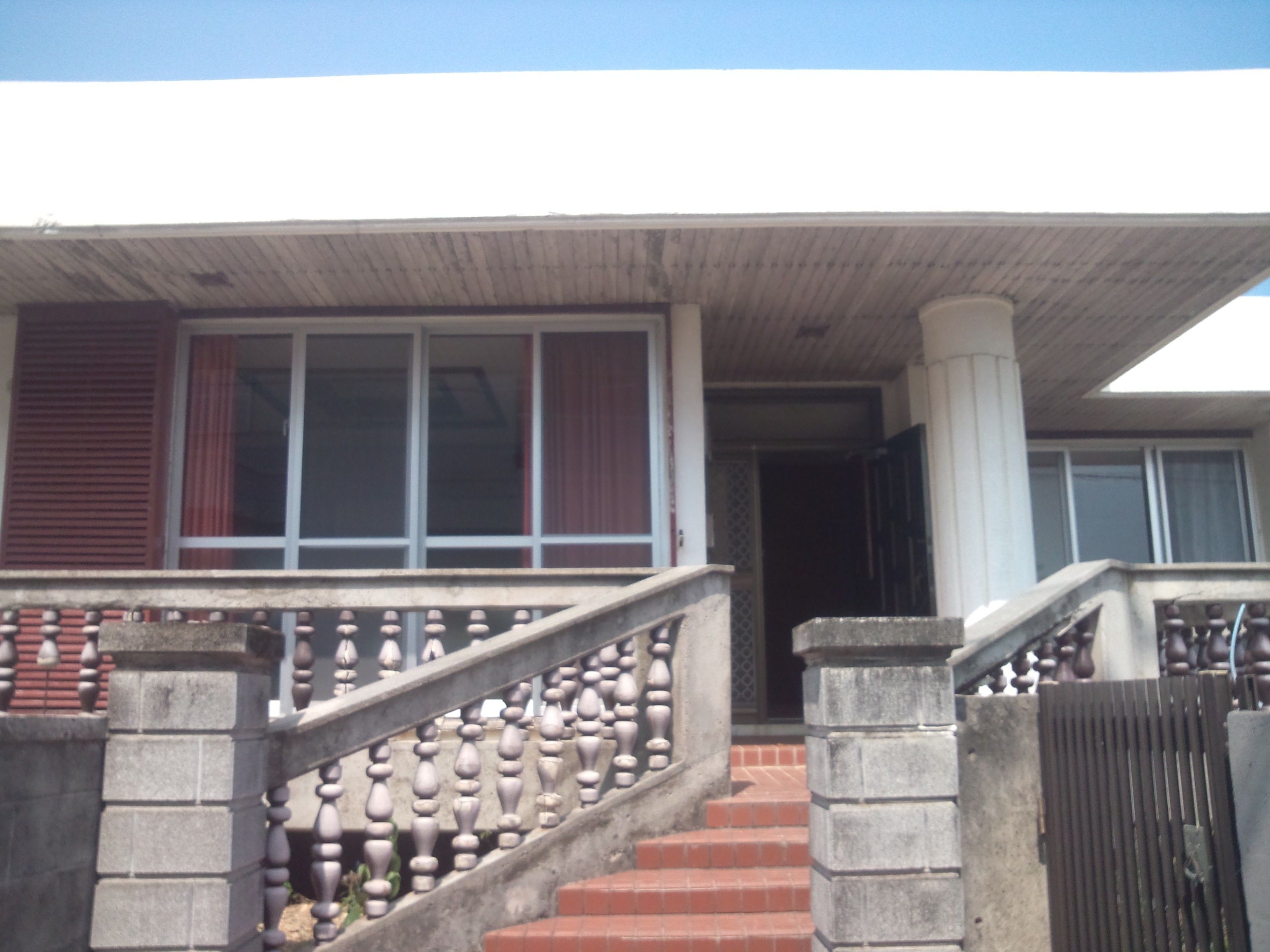 A staircase with a balustrade leading to a covered porch area.