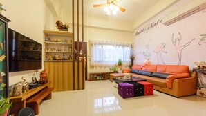 A living room with a sofa, a coffee table, a TV, and a bookshelf. - Puli Waltz Villa (Puli)