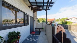 A covered outdoor area with a checkered floor, a bench, and a small table with items on it. - Puli Waltz Villa (Puli)