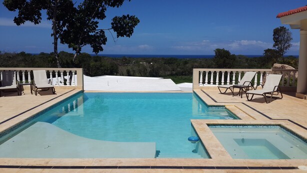A rectangular pool with a clear blue water surface, surrounded by a white balustrade and beige tiles. - Sosua villa tropical retreat with ocean views (Sosúa)
