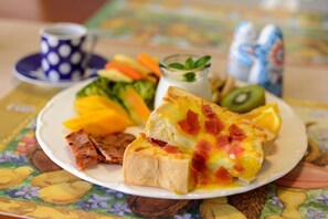 A plate with a slice of quiche, a piece of ham, and a variety of vegetables including carrots and broccoli. - Bella Forest (Puli)