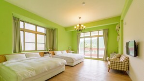 Ein Hotelzimmer mit zwei Betten, einem Fernseher, einer Kristallleuchtre und einem karierten Sessel.