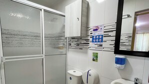 Een badkamer met toilet, hygiëneschuimer en wastafel.