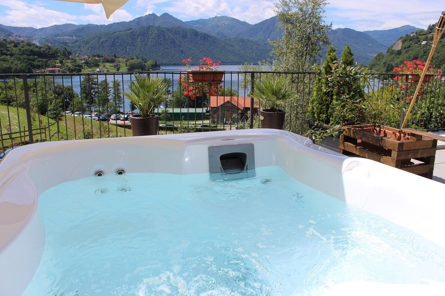 A hot tub with a view of mountains and a lake.