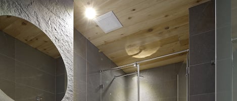 Un baño moderno con un lavamanos amplio, espejo y ducha.